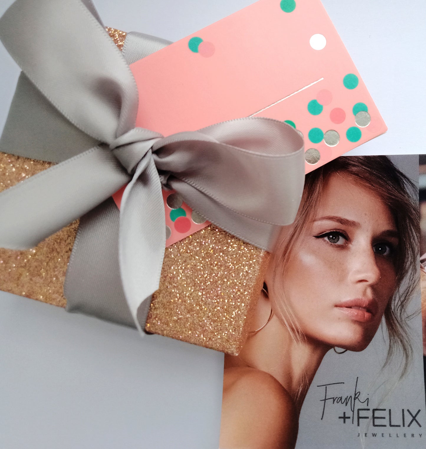 rose gold glitter gift box with pink gift card wrapped in grey satin ribbon with postcard